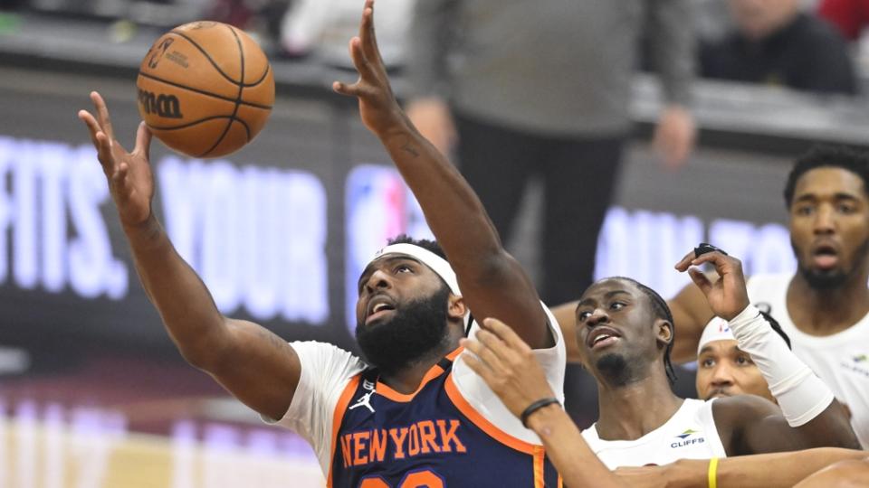 Apr 26, 2023; Cleveland, Ohio, USA; New York Knicks center Mitchell Robinson (23) reaches for a rebound beside Cleveland Cavaliers guard Caris LeVert (3) in the first quarter during game five of the 2023 NBA playoffs at Rocket Mortgage FieldHouse.