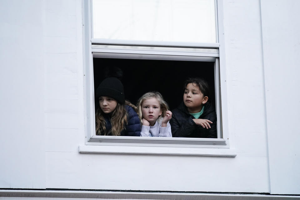 Children watch from a window as President Joe Biden visits shops in Nantucket, Mass., Friday, Nov. 24, 2023. (AP Photo/Stephanie Scarbrough)