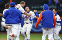 New York Mets' Tyrone Taylor (15) celebrates with teammates after he drove in the winning run against the Detroit Tigers during the ninth inning in the second game of a baseball doubleheader Thursday, April 4, 2024, in New York. The Mets won 2-1. (AP Photo/Noah K. Murray)