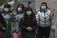 Students wearing face masks to help curb the spread of the coronavirus leave their school after classes in Beijing, Monday, Nov. 29, 2021. Despite the global worry, scientists caution that it's still unclear whether the omicron COVID-19 variant is more dangerous than other versions of the virus that has killed more than 5 million people. Some countries are continuing with previous plans to loosen restrictions, with signs of reopening in Malaysia, Singapore and New Zealand. (AP Photo/Andy Wong)