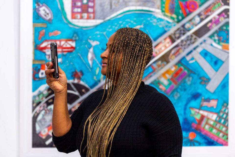 Patron Ayanna Solomon facetimes a relative to show the artwork at the Art Prizm Fair during Art Basel in the Design District neighborhood of Miami, Florida, on Tuesday, November 29, 2022.