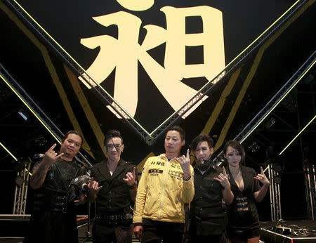 Freddy Lim (C), a candidate to the 2016 legislative election and singer of death metal band Chthonic, and members of Chthonic pose for photographers during an interview with reporters after a concert to boost his campaign in Taipei, Taiwan, December 26, 2015. REUTERS/Pichi Chuang