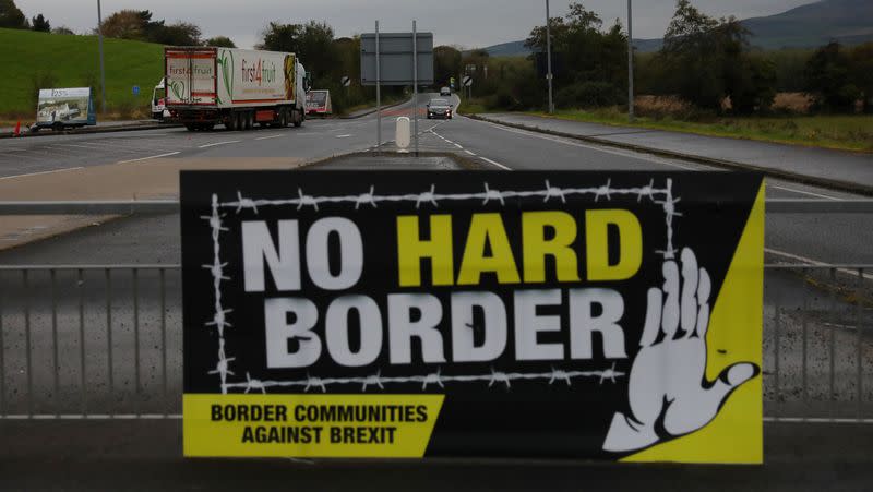 A lorry drives past a 'No Hard Border' poster near Londonderry, Northern Ireland
