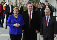 German Chancellor Angela Merkel, left, greets United Nations Secretary General Antonio Guterres, right, and U.S. Secretary of State Mike Pompeo, center, during arrivals for a conference on Libya at the chancellery in Berlin, Germany, Sunday, Jan. 19, 2020. German Chancellor Angela Merkel hosts the one-day conference of world powers on Sunday seeking to curb foreign military interference, solidify a cease-fire and help relaunch a political process to stop the chaos in the North African nation. (AP Photo/Jens Meyer)