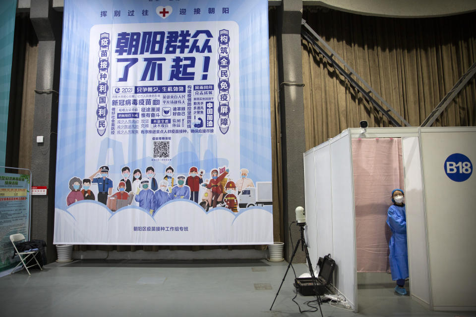 A worker waits inside an injection booth during a COVID-19 vaccination session for resident foreign journalists at a vaccination center in Beijing, Tuesday, March 23, 2021. Chinese medical firm Sinovac said its COVID-19 vaccine is safe in children ages 3-17, based on preliminary data, and it has submitted the data to Chinese drug regulators. State-owned Sinopharm, who has two COVID-19 vaccines, is also investigating the effectiveness of its vaccines in children. (AP Photo/Mark Schiefelbein)