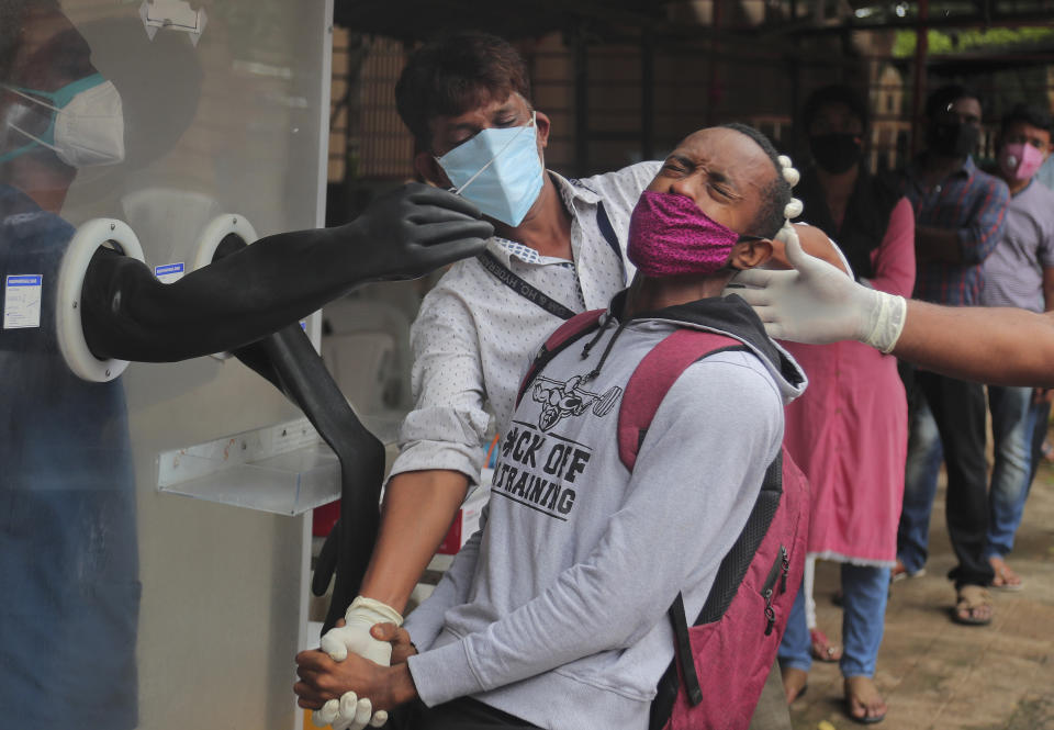 A man reacts as health workers help collect a nasal swab sample to test for COVID-19 in Hyderabad, India, Thursday, Sept. 17, 2020. As India’s coronavirus confirmed cases jump by a record 97,894 cases in the past 24 hours, Prime Minister Narendra Modi’s government faced a scathing opposition criticism in Parliament for its handling of the pandemic and a contracting economy leaving millions jobless on Thursday. (AP Photo/Mahesh Kumar A.)