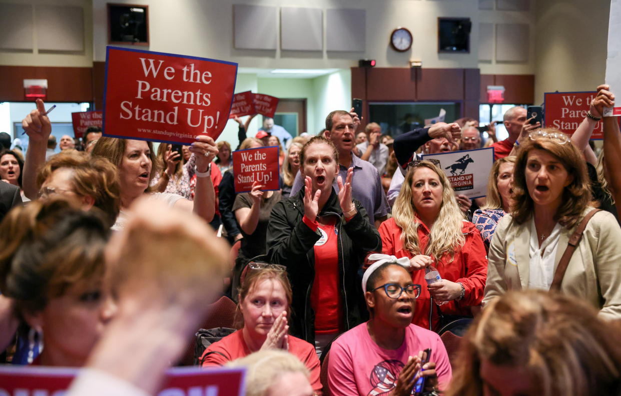 Angry community members and parents in Ashburn, Va., in June last year sing 