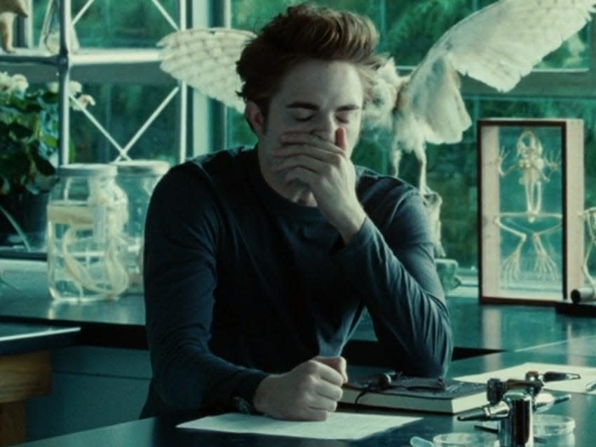 Edward sitting in a science lab and covering his mouth and nose with his hand