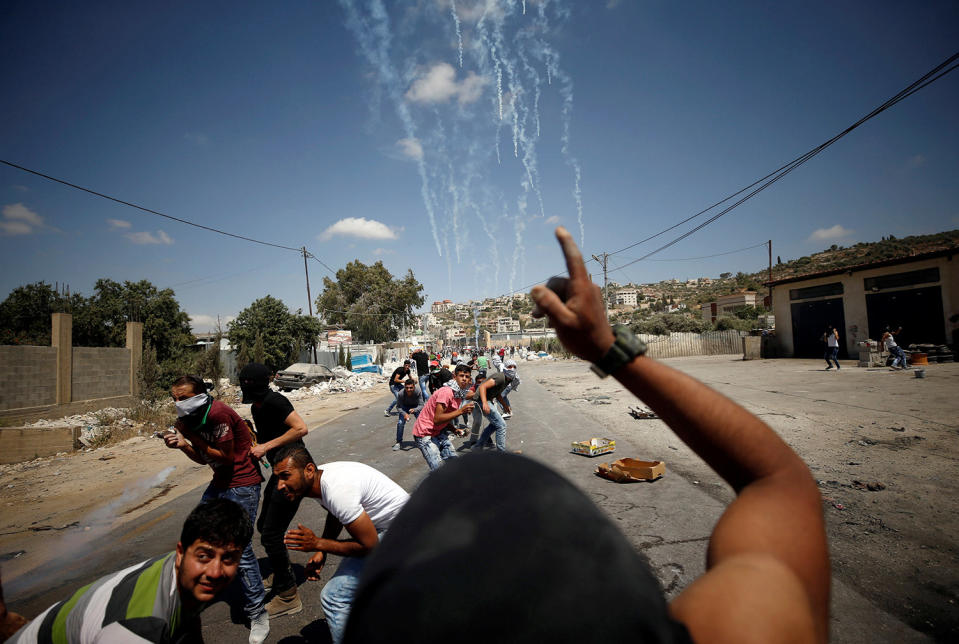 <p>Palestinian protesters take cover during clashes with Israeli troops following a protest in support of Palestinian prisoners on hunger strike in Israeli jails, in the West Bank village of Beita, near Nablus May 19, 2017. (Photo: Mohamad Torokman/Reuters) </p>