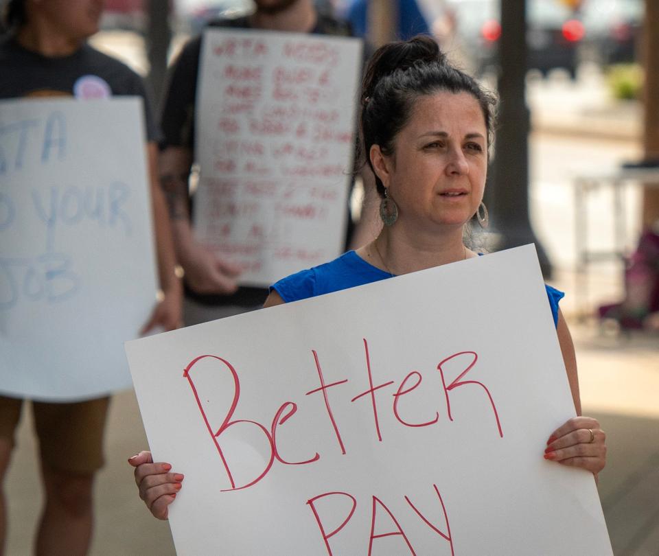 City Councilor Etel Haxhiaj takes a break from campaigning to hold a sign supporting WRTA bus drivers at the bus hub Tuesday.