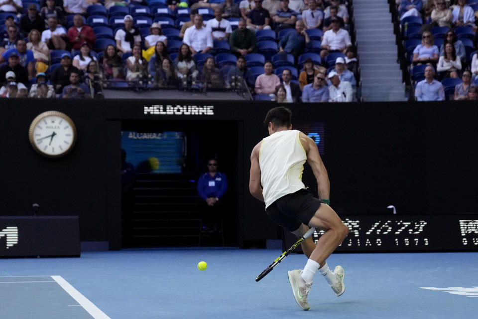 Carlos Alcaraz of Spain plays a shot back between his legs to Lorenzo Sonego of Italy during their second round match at the Australian Open tennis championships at Melbourne Park, Melbourne, Australia, Thursday, Jan. 18, 2024. (AP Photo/Andy Wong)