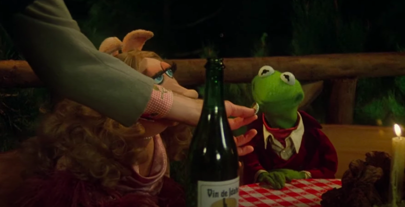 A frog sniffs the cap of a wine bottle