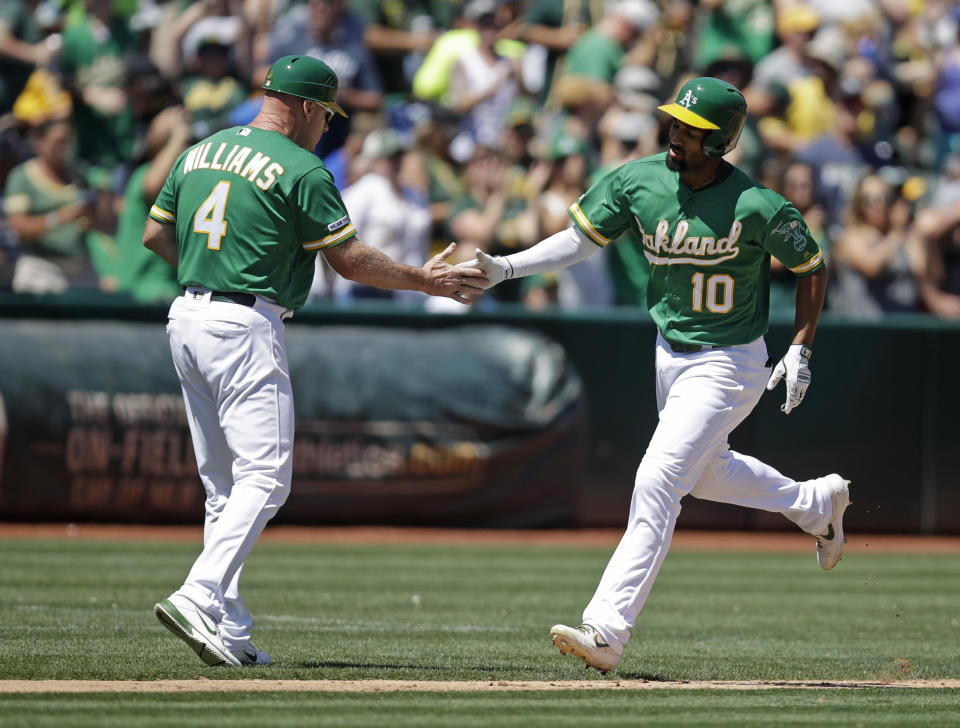 Oakland Athletics' Marcus Semien, right, is congratulated by third base coach Matt Williams (4) after hitting a home run off Houston Astros' Zack Greinke in the fourth inning of a baseball game Sunday, Aug. 18, 2019, in Oakland, Calif. (AP Photo/Ben Margot)