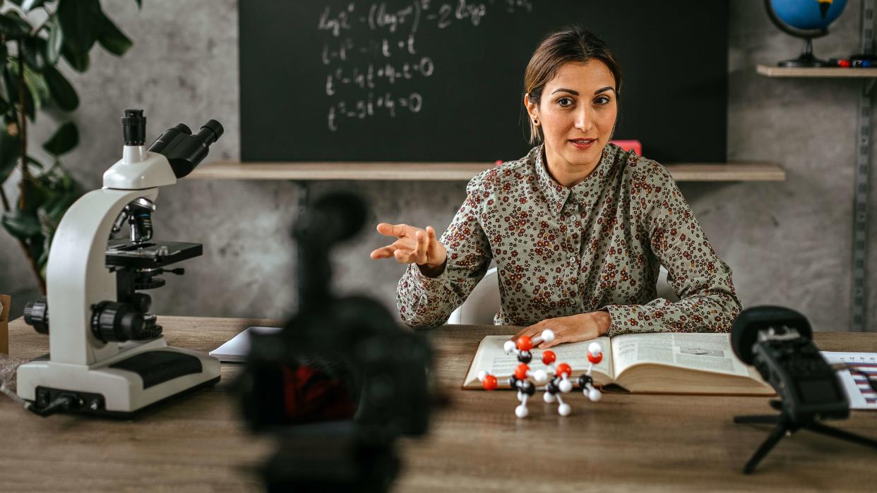 Female professor recording educational training tutorial for vlogging on camera.