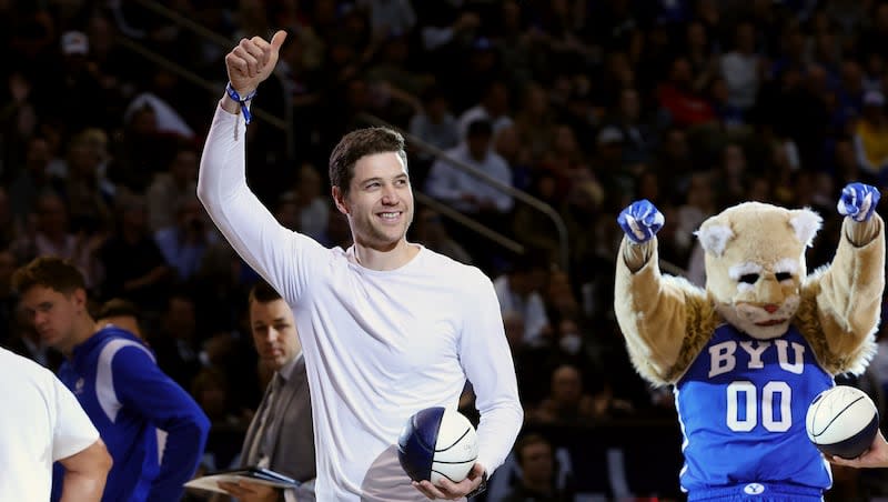 Former BYU star Jimmer Fredette gives fans a thumbs up during a timeout as BYU and Utah play at the Marriott Center in Provo on Saturday, December 17, 2022. BYU won 75-66.