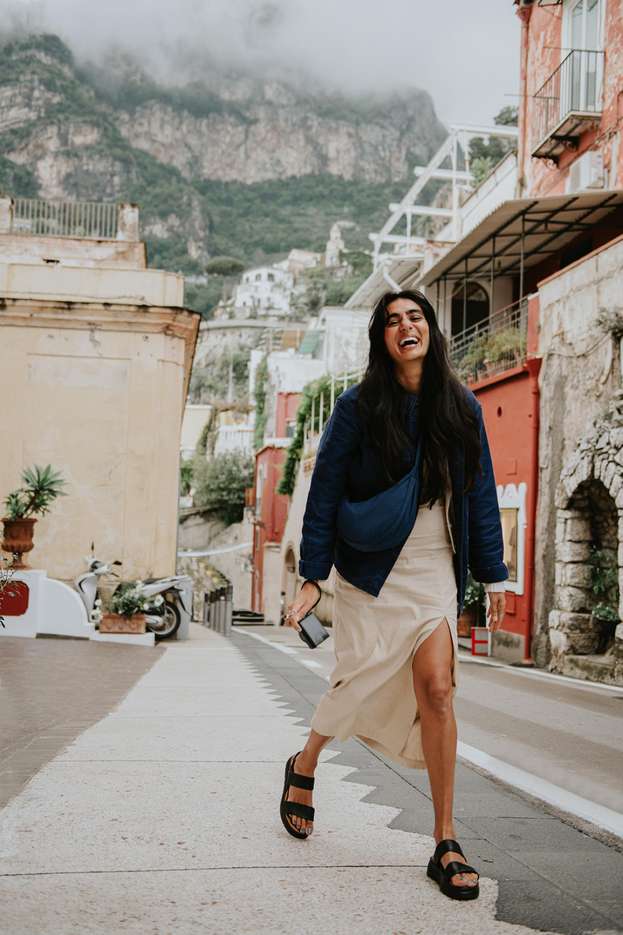 A young woman walks through a narrow street of Positano, on the Almalfi Coast in Italy.