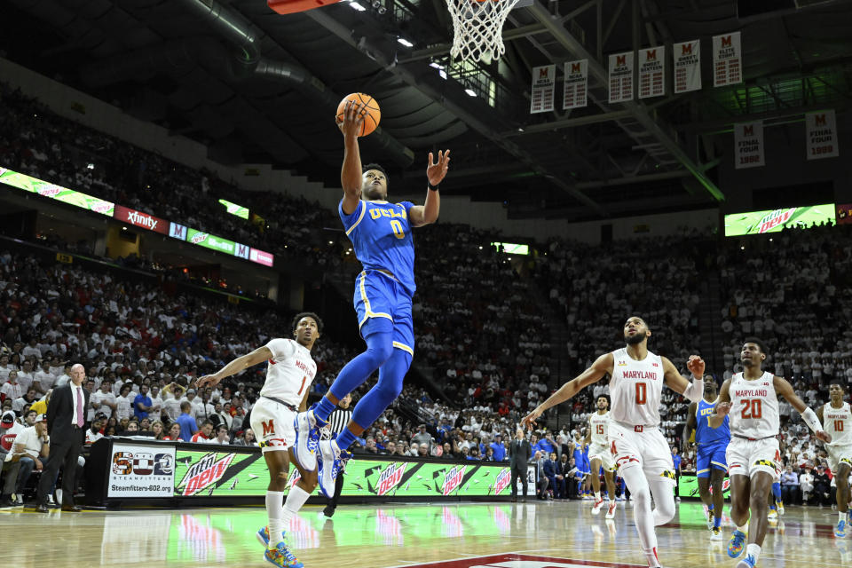 UCLA guard Jaylen Clark (0) goes to the basket for lay up and is fouled by Maryland guard Jahmir Young (1) during the first half of an NCAA college basketball game, Wednesday, Dec. 14, 2022, in College Park, Md. (AP Photo/Terrance Williams)