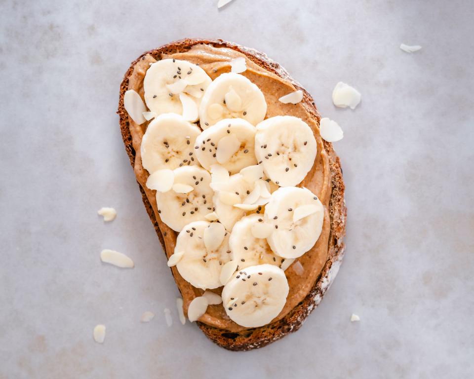 slice of sourdough toast with peanut butter, banana, chia seeds and almond flakes