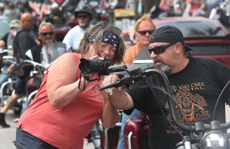 A photographer shows a rider a memorable image on Monday as motorcycles roared along Main Street during Bike Week in Daytona Beach. The 10-day event continues through Sunday in Daytona Beach and throughout Central Florida.