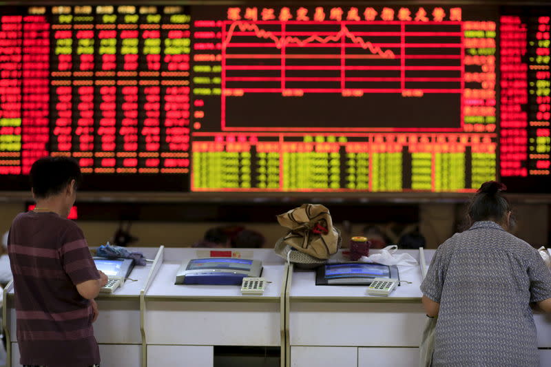 Investors look at computer screens in front of an electronic board showing stock information at a brokerage house in Shanghai, China, September 7, 2015. REUTERS/Aly Song/Files