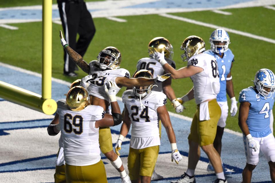 Notre Dame running back Kyren Williams (23) is lifted into the air by offensive lineman Aaron Banks (69) after he scored a touchdown against North Carolina at Kenan Memorial Stadium.
