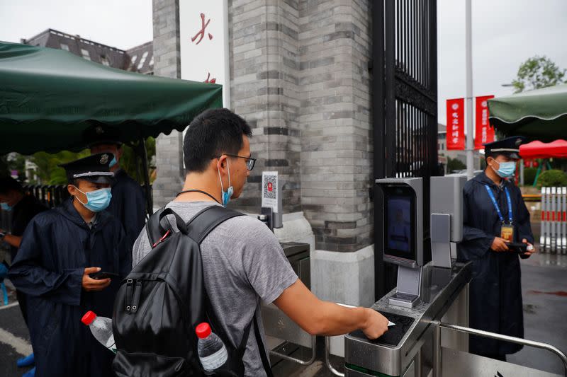 People pass facial recognition camera-controlled gates to enter Peking University as Chinese students gradually return to their campuses after an outbreak of the coronavirus disease (COVID-19) in Beijing, China