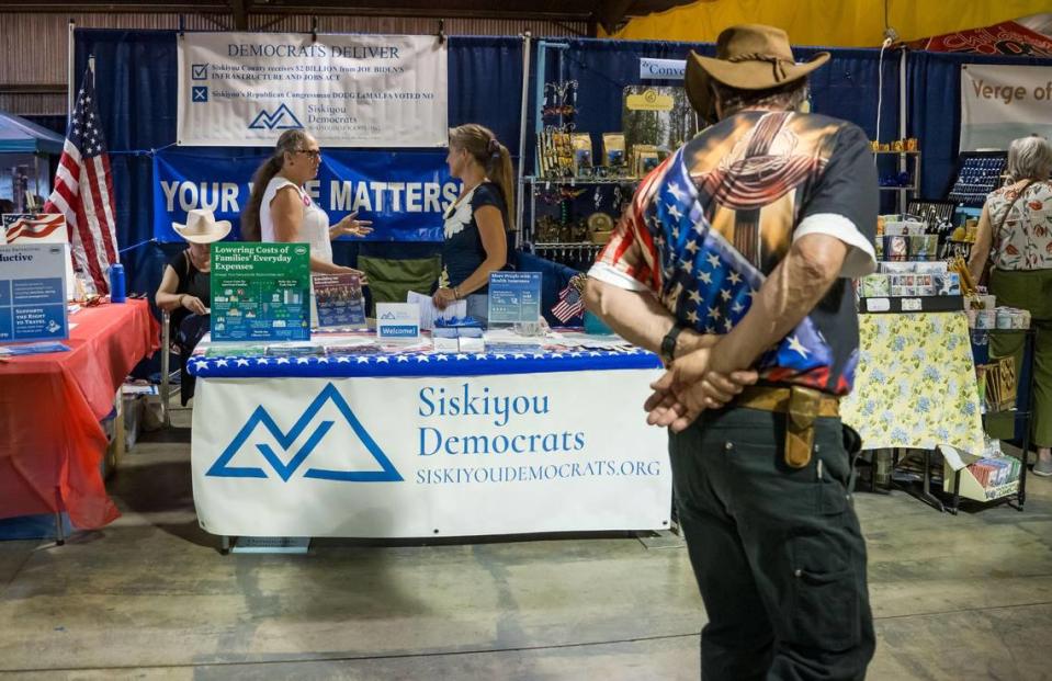 Alice Rogers, left, chair of the Democratic Central Committee of Siskiyou County, and Angelina Cook, a longtime county resident running for the Board of Supervisors, chat while a fair-goer slowly walks past their table at the Siskiyou Golden Fair on Aug. 9 in Yreka. Xavier Mascareñas/xmascarenas@sacbee.com