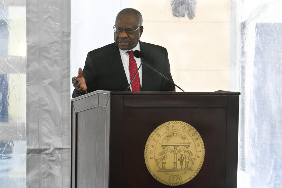 Supreme Court Associate Justice Clarence Thomas motions to former Georgia Governor Nathan Deal while delivering a keynote address during a dedication of the state's new Nathan Deal Judicial Center, Tuesday, Feb. 11, 2020, in Atlanta. The ceremony, due to rain, was held in a tent outside the new center which is being named for the former governor and is the first state building in the history of Georgia that is devoted entirely to the judiciary. (AP Photo/John Amis)