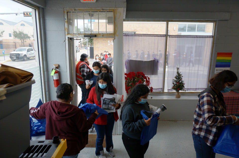 People line up inside and outside the migrant welcome center across from the bus station in Brownsville, Texas, on Friday, Dec. 16, 2022. Volunteers from Team Brownville at the center handed out food and necessities, like toothpaste and socks, to migrants that U.S. officials detained and released across the street. Most of Friday's group said they were from Nicaragua, with a few from the Dominican Republic. (AP Photo/Giovanna Dell'Orto)