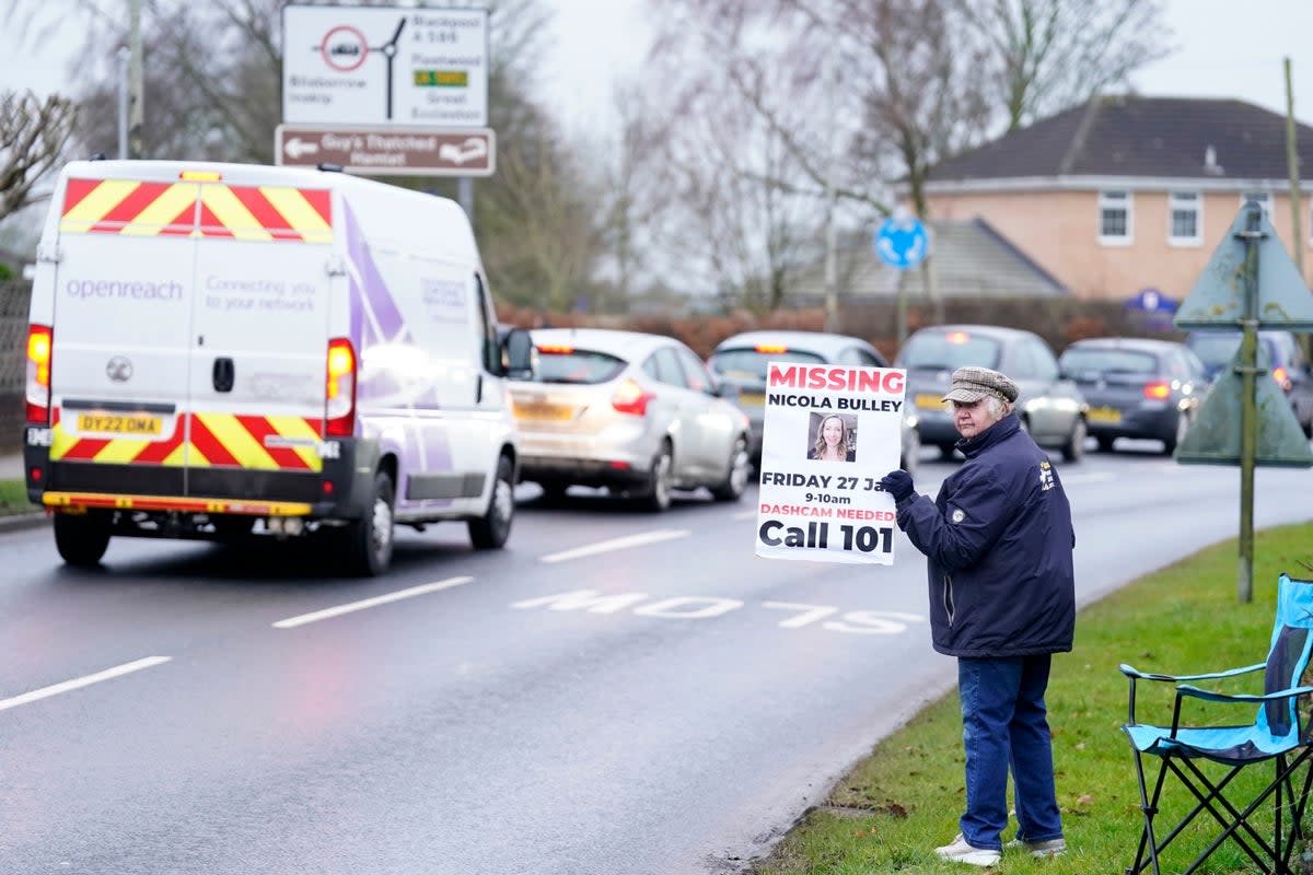 3 February 2023: A member of the public lines the road into St Michael’s on Wyre, Lancashire, with missing posters of Nicola Bulley, 45, as police continue their search for the missing woman who was last seen on the morning of Friday January 27, when she was spotted walking her dog on a footpath by the nearby River Wyre (PA)