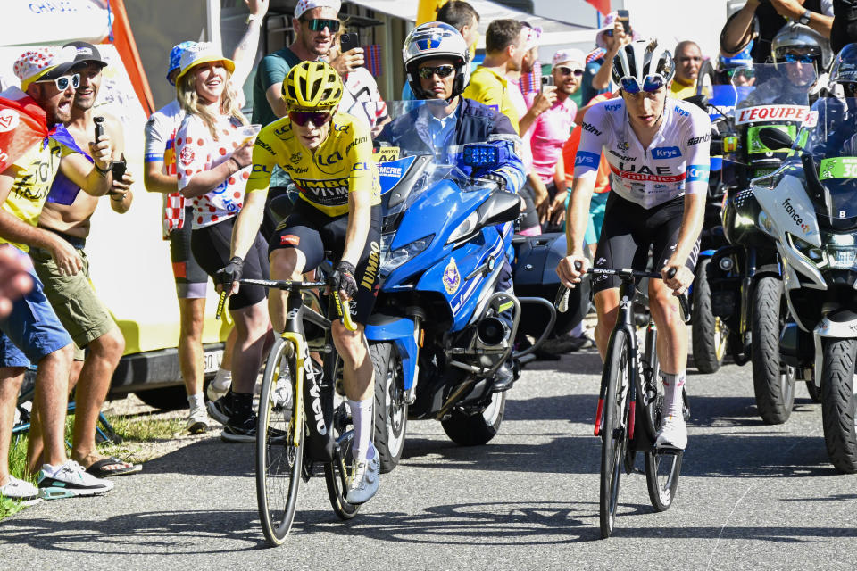 El danés Jonas Vingegaard, con el maillot amarillo y el esloveno Tadej Pogacar, con el maillot blanco al mejor joven pasan por el ascenso de Joux Plan en la 14ma etapa del Tour de Francia el sábado 15 de julio del 2023. (Bernard Papon/Pool Photo via AP)