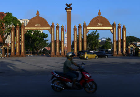 A motorcyclist passes by the Sultan Ismail Petra Arch, a landmark of Kota Bharu in Kelantan, Malaysia April 13, 2018. REUTERS/Stringer