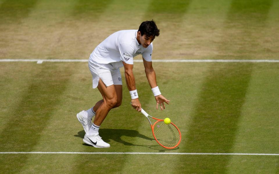 Chile's Cristian Garin attempts to return the ball to Australia's Alex De Minaur during a men's singles fourth round match on day eight of the Wimbledon tennis championships in London, Monday, July 4, 2022 - Kirsty Wigglesworth/AP