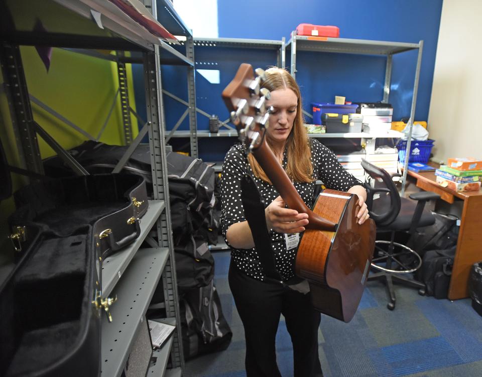 Allison Howell handles an acoustic guitar available for borrowing at the "Library of Things" at the Mansfield-Richland County Public Library Main Branch.