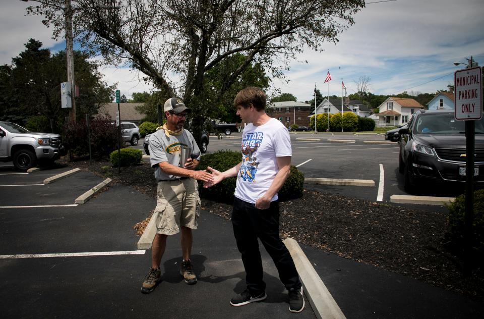 Wayne Sulken and Chris Karnes, both Bethel residents, shake hands after having a discussion in the parking lot of the Bethel Municipal Building on Tuesday, June 16. 