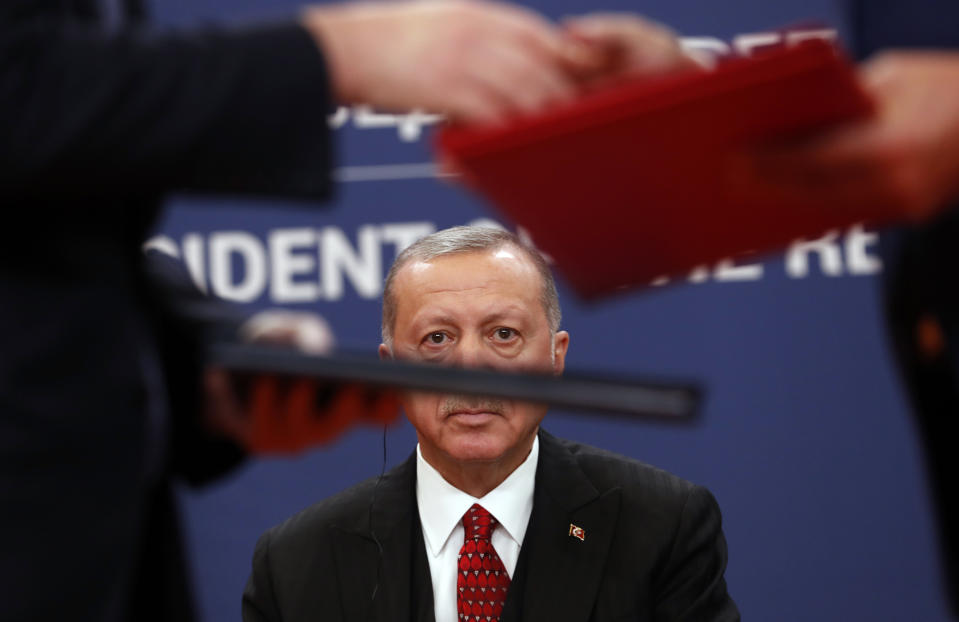 FILE - Turkey's President Recep Tayyip Erdogan, center, looks on as documents are exchanged after the signing of an agreement after talks with his Serbian counterpart Aleksandar Vucic in Belgrade, Serbia, on Oct. 7, 2019. Erdogan, who is seeking a third term in office as president in elections in May, marks 20 years in office on Tuesday, March 14, 2023. (AP Photo/Darko Vojinovic, File)