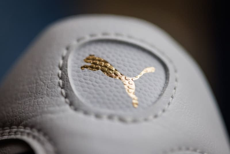 The logo of the sporting goods manufacturer Puma can be seen on one of the brand's shoes. Daniel Karmann/dpa