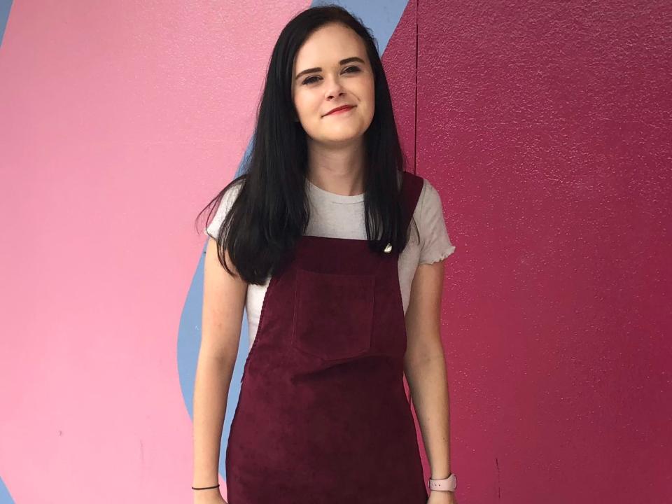 sam posing at the bubblegum pink wall at epcot