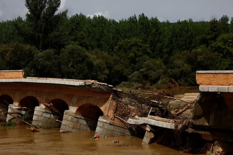 Miembros del equipo de búsqueda y rescate de la Guardia Civil española buscan a una persona desaparecida junto a un puente que se derrumbó parcialmente, tras las fuertes lluvias en Aldea del Fresno, España