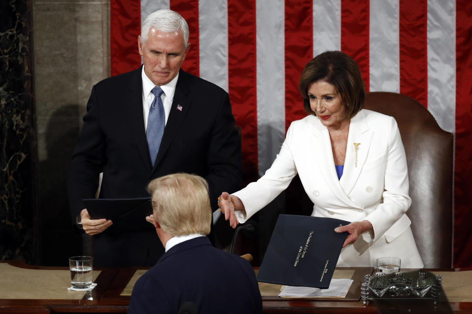 President Donald Trump hands copies of his speech to House Speaker Nancy Pelosi of Calif., and Vice President Mike Pence as he delivers his State of the Union address to a joint session of Congress on Capitol Hill in Washington, Tuesday, Feb. 4, 2020. (Patrick Semansky/AP)