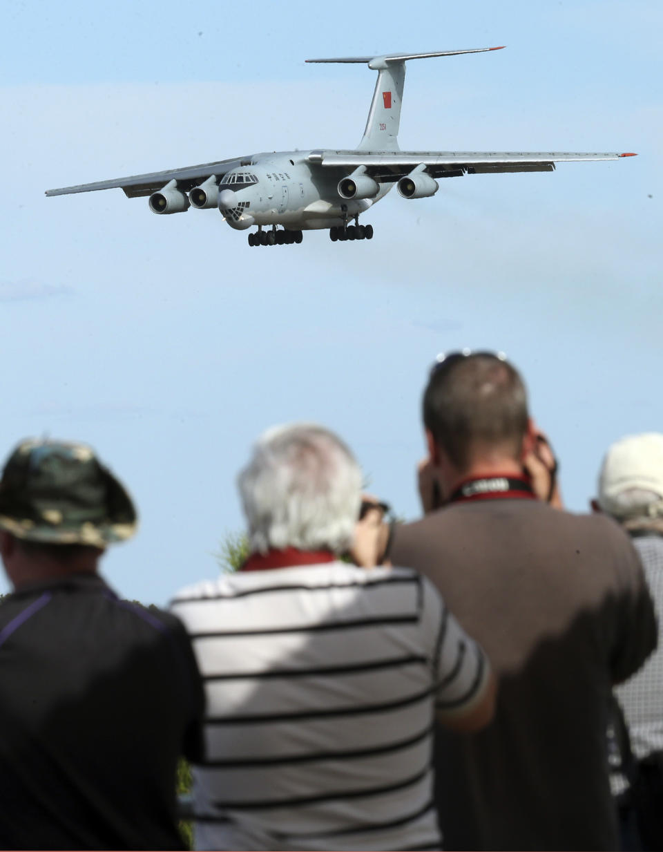 Spectators take photos of a Chinese Ilyushin IL-76 aircraft as it comes in for a landing at Perth International Airport after returning from the ongoing search operations for missing Malaysia Airlines Flight 370 in Perth, Australia, Thursday, April 10, 2014. With hopes high that search crews are zeroing in on the missing Malaysian jetliner's crash site, ships and planes hunting for the aircraft intensified their efforts Thursday after equipment picked up sounds consistent with a plane's black box in the deep waters of the Indian Ocean. (AP Photo/Rob Griffith)