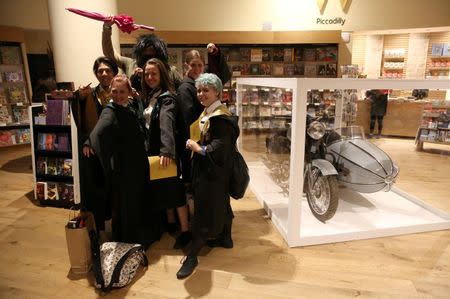 Fans in costume pose with a movie prop at an event to mark the release of the book of the play of Harry Potter and the Cursed Child parts One and Two at a bookstore in London, Britain July 30, 2016. REUTERS/Neil Hall