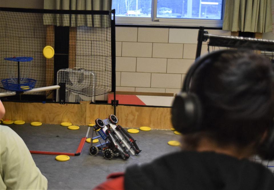 West Holmes freshman Lily Galehouse controls her robot to shoot a disk into the basket in the makeshift  laboratory at West Holmes Middle School.