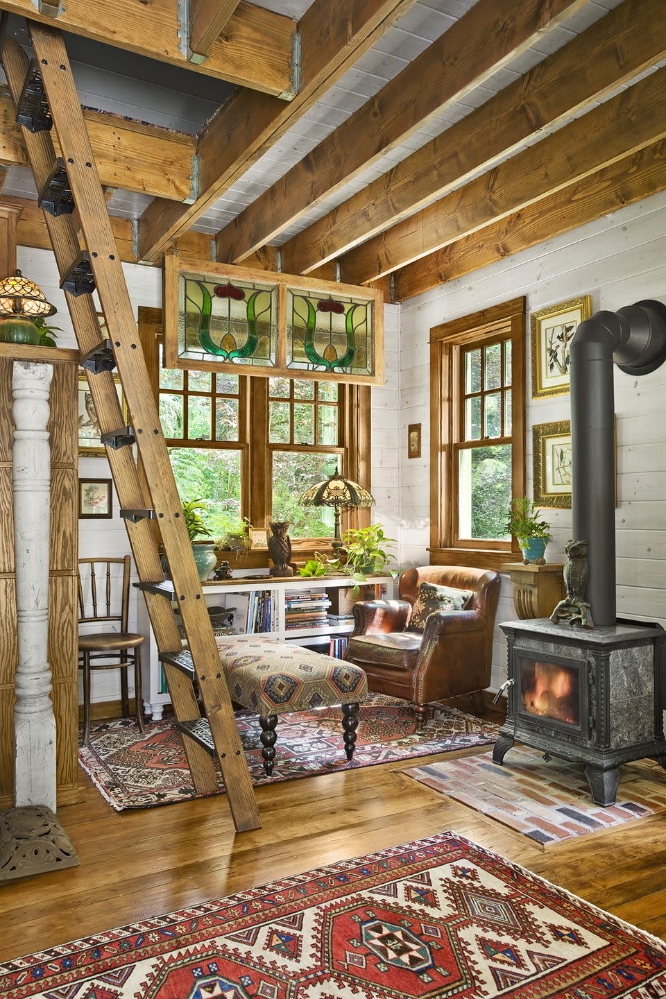 <p>When square footage is tight, it helps if statement pieces are both charming and useful. An old wood-burning stove brings a vintage vibe to new construction and also heats the entire place.</p><p><a class="link " href="https://www.amazon.com/Tiny-House-Living-Building-Square/dp/1440333165/?tag=syn-yahoo-20&ascsubtag=%5Bartid%7C10050.g.1887%5Bsrc%7Cyahoo-us" rel="nofollow noopener" target="_blank" data-ylk="slk:SHOP TINY HOUSE BOOKS;elm:context_link;itc:0;sec:content-canvas">SHOP TINY HOUSE BOOKS</a></p>