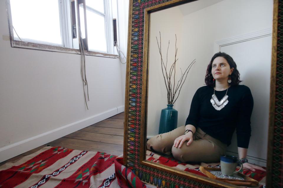 Deema Totah, a native of Palestine, is reflected in a mirror in her home Tuesday, Jan. 16, 2024 in Iowa City, Iowa.