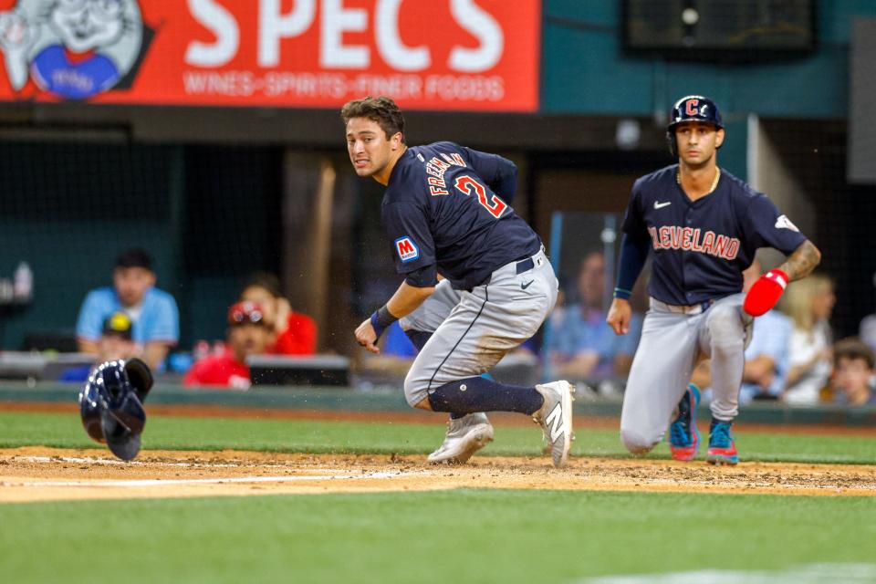 Guardians outfielder Tyler Freeman (left) and shortstop Brayan Rocchio both score during the eighth inning against the Rangers, May 13, 2024, in Arlington, Texas.