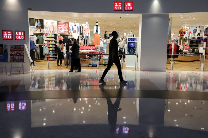 FILE PHOTO: A man wearing a face mask walks past a Uniqlo store, amid the coronavirus disease (COVID-19) outbreak in Petaling Jaya