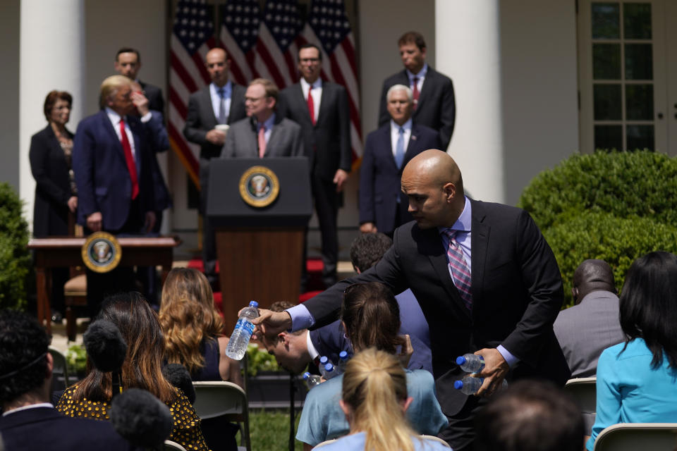 Water is handed out to members of the press as President Donald Trump holds a news conference in the Rose Garden of the White House, Friday, June 5, 2020, in Washington. (AP Photo/Evan Vucci)