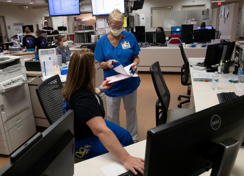 Registered nurse Melanie Bailey and Karen Tilton share patient care information during a typical work day at the emergency room at Baptist Health Care's Gulf Breeze Hospital. Employers like Baptist Health Care are becoming more competitive and innovative in their efforts to attract and retain employees in the current economy.