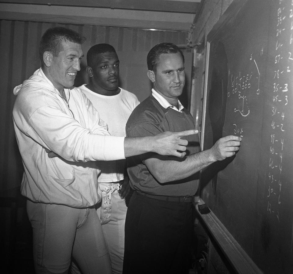 Baltimore coach Don Shula, right, goes over a play diagram with quarterback John Unitas, left, and Lenny Moore on Nov. 4, 1964 in Baltimore, Md. Moore said every Black athlete owes Sam Lacy a debt of gratitude.